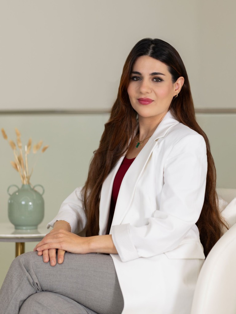 Dr. Rawan Al-Tawashi, Clinical Nutritionist and Body Contouring Devices expert, posing in a modern clinic environment.